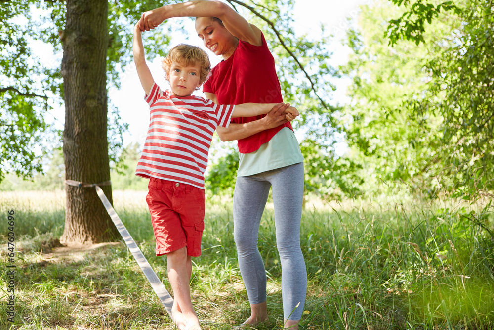 Obraz premium Son slacklining with mother in garden