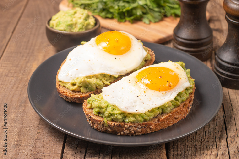 Two avocado open sandwiches with egg. Keto and diet concept. Healthy toast food for breakfast. Two avocado open sandwiches with egg. Keto and diet concept. Healthy toast food for breakfast.