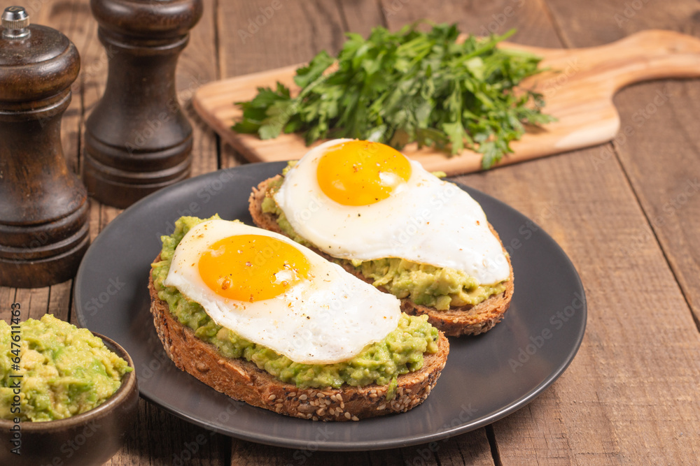 Two avocado open sandwiches with egg. Keto and diet concept. Healthy toast food for breakfast. Two avocado open sandwiches with egg. Keto and diet concept. Healthy toast food for breakfast.
