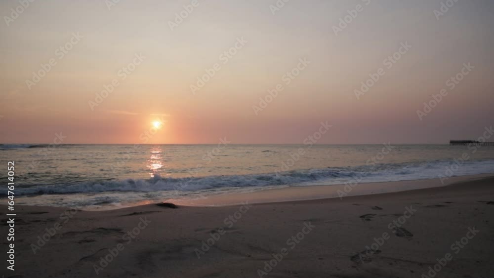 Wide side angle of the sun setting over the ocean with the Swakopmund Jetty in the distance in Namibia Wide side angle of the sun setting over the ocean with the Swakopmund Jetty in the distance in Namibia