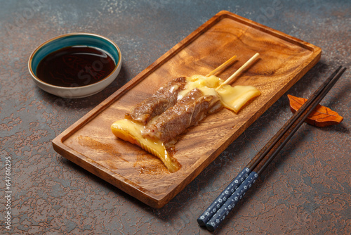 Yakitori boeuf fromage surr un plateau en bois et avec une sauce soja. Brochette de viande. 