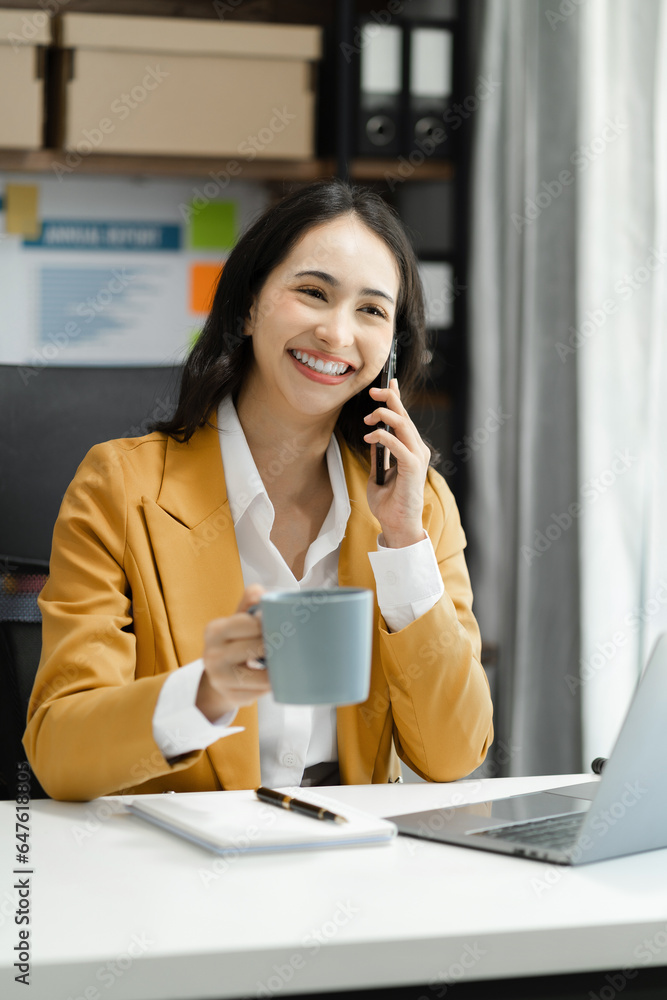 Asian business woman using mobile phone in office. Asian business woman using mobile phone in office.