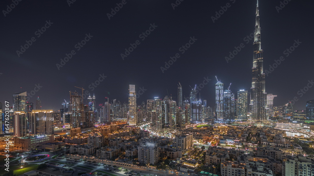 Fototapeta premium Panorama showing Dubai's business bay towers aerial night timelapse. Rooftop view of some skyscrapers