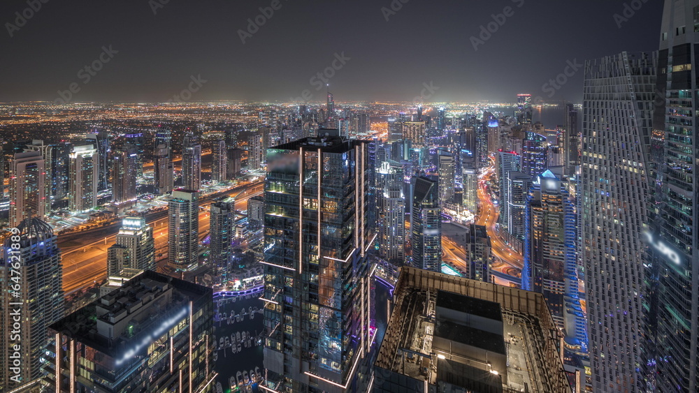 Obraz premium Panorama showing JBR district and Dubai Marina with JLT. Traffic between skyscrapers aerial night timelapse.