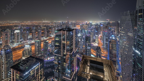 Panorama showing JBR district and Dubai Marina with JLT. Traffic between skyscrapers aerial night timelapse.