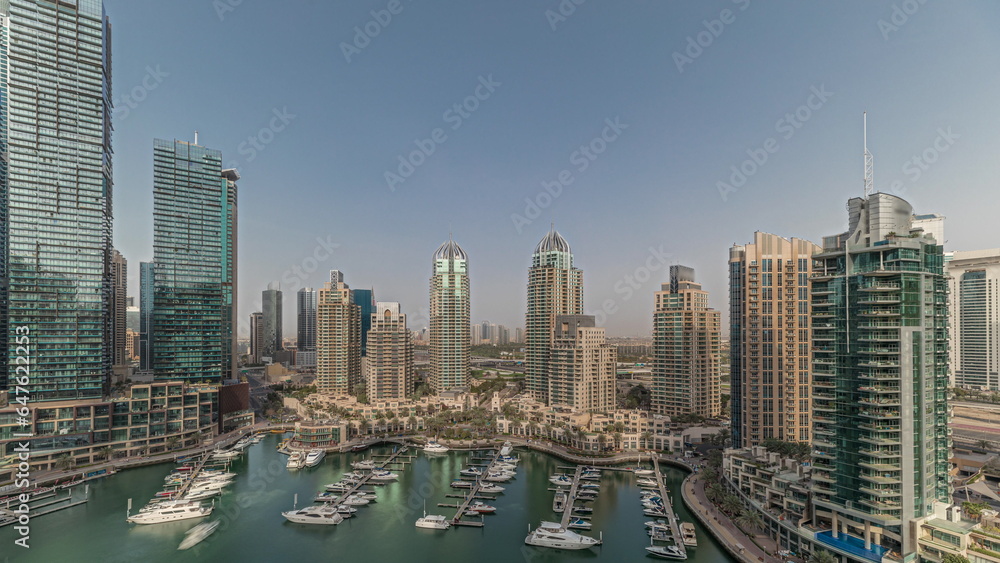 Fototapeta premium Panorama showing Dubai marina tallest skyscrapers and yachts in harbor aerial timelapse.