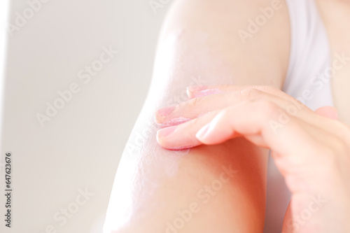 美容のために腕にクリームを塗る女性