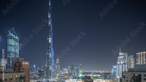 Panorama showing aerial cityscape night timelapse with illuminated architecture of Dubai downtown.