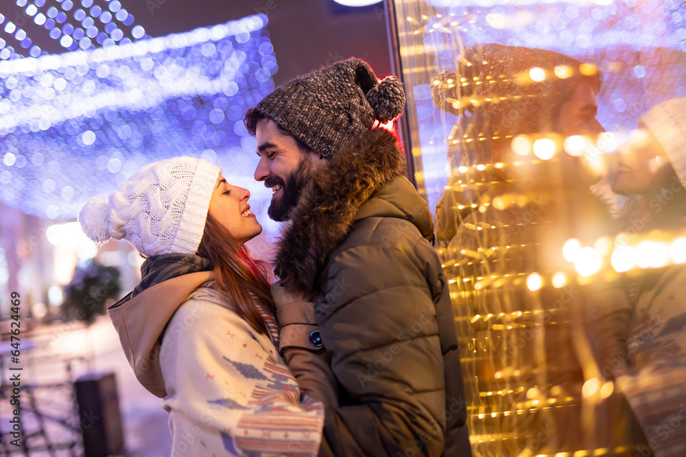 Couple kissing in city streets on Christmas Eve Couple kissing in city streets on Christmas Eve