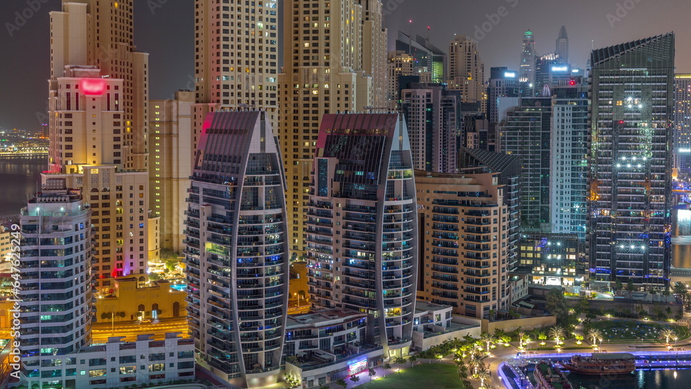 Dubai Marina skyscrapers and JBR district with luxury buildings and resorts aerial timelapse during all night with lights turning off