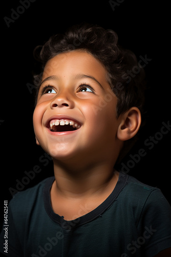 Studio portrait of cute little laughing boy on different colour background