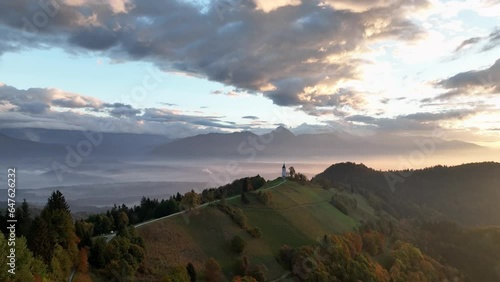Aerial of a rural chapel on a hill at sunrise in Slovenia photo