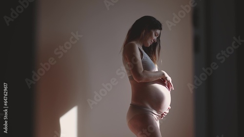 pregnant woman. indoors health pregnancy motherhood procreation concept. close-up belly of a pregnant woman. woman waiting for a newborn baby. pregnant woman holding her belly sunlight