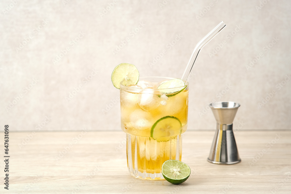 Fototapeta premium Iced tea with lime on a wooden table, refreshing drink 