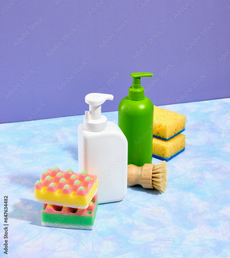 Dish washing supplies. Colorful dishwashing sponges and white and green washer dispensers with detergent. Dish washing supplies. Colorful dishwashing sponges and white and green washer dispensers with detergent.