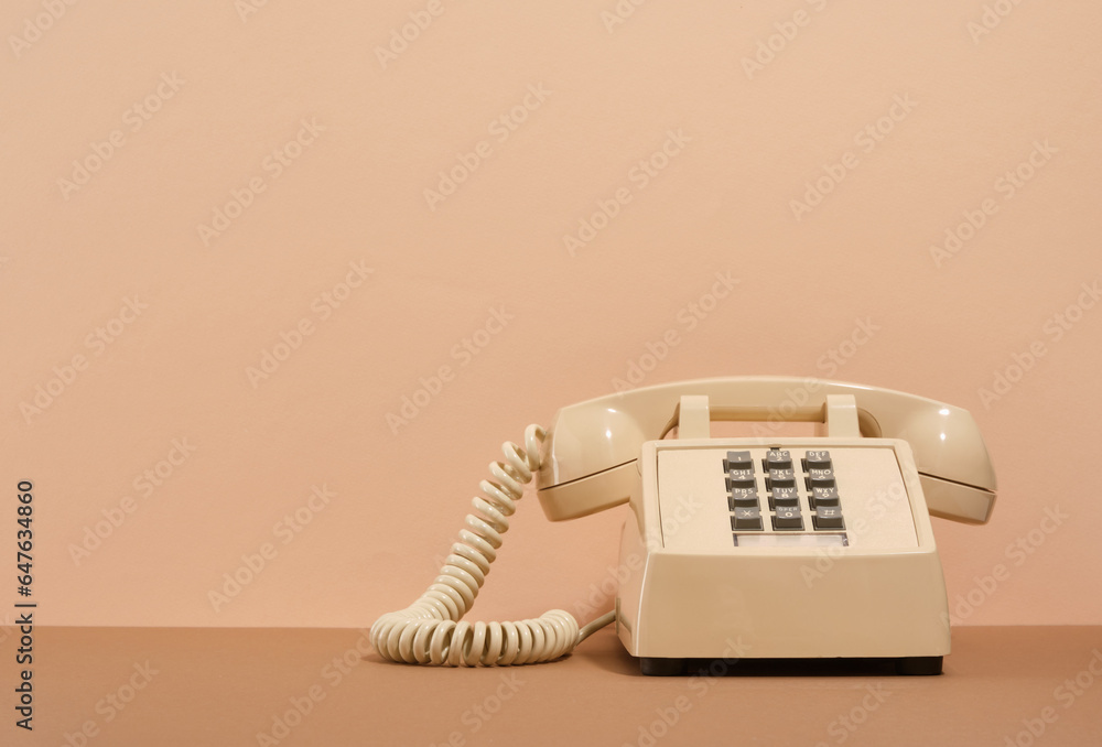Beige phone with gray buttons on a beige background. Copy space for text. Retro style. - obrazy, fototapety, plakaty 