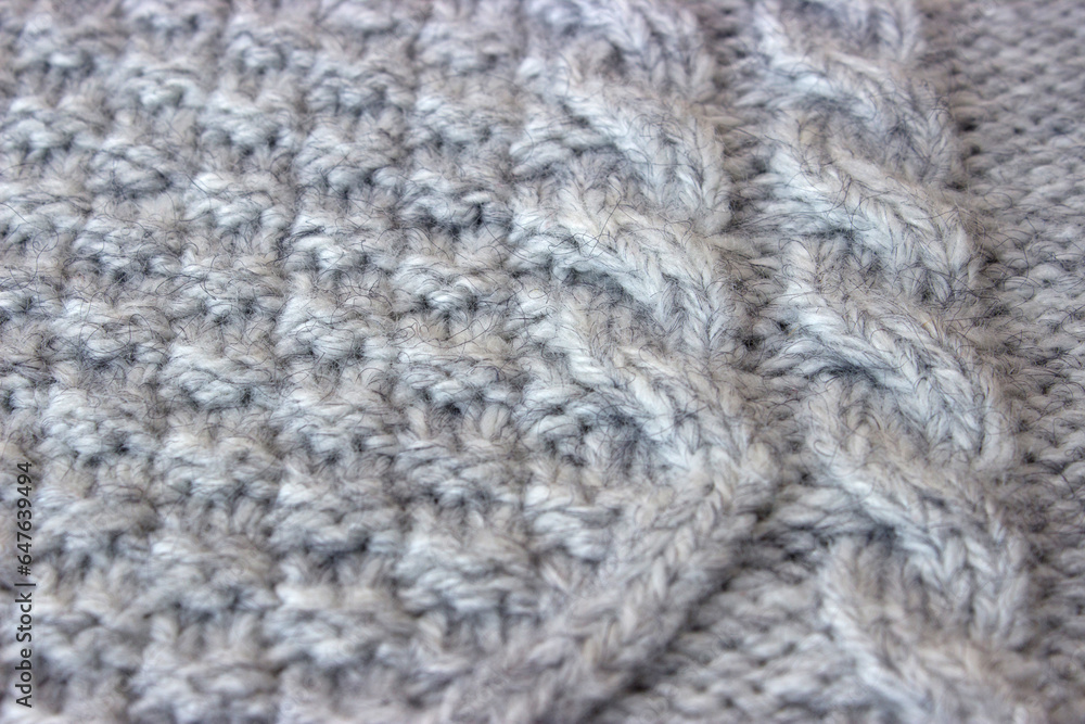 Texture of gray knitted sweater with braids Texture of gray knitted sweater with braids