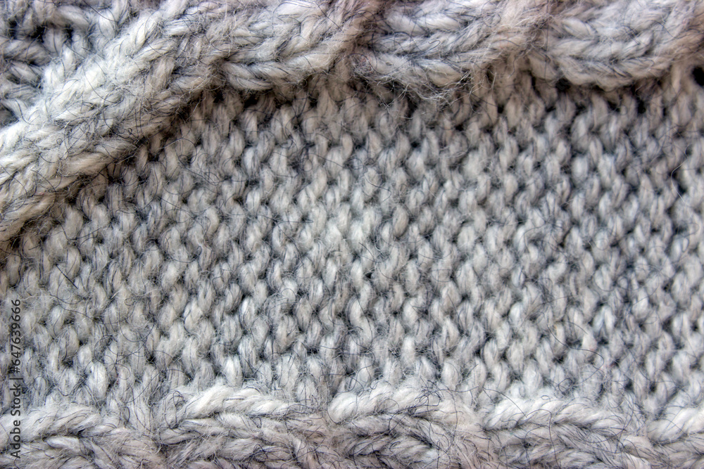 Texture of gray knitted sweater with braids