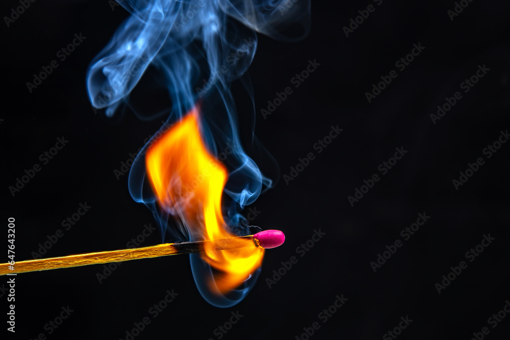Fire and smoke. Burning and smoking match on a black background. Heat and light from fire flame Fire and smoke. Burning and smoking match on a black background. Heat and light from fire flame
