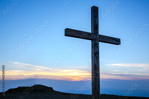 wooden cross on a background of sunrise in the mountains