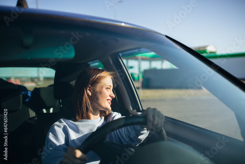 female driver driving a car on a sunny day. The pleasure of driving a car.