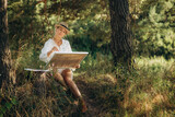 a woman paints while sitting in nature