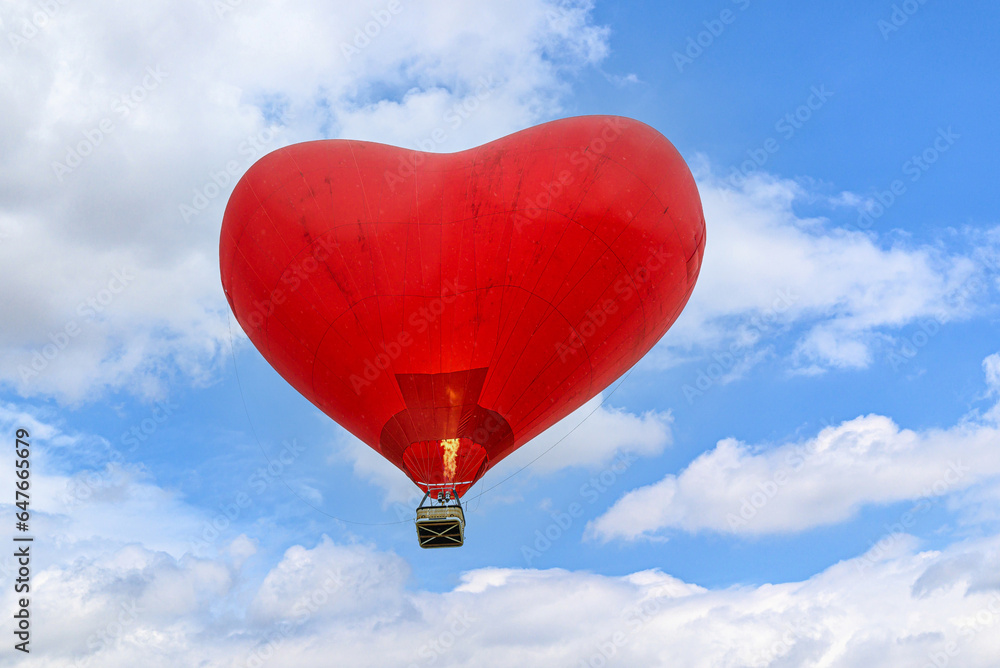 Colorful hot air balloon flying over blue sky with white clouds Colorful hot air balloon flying over blue sky with white clouds