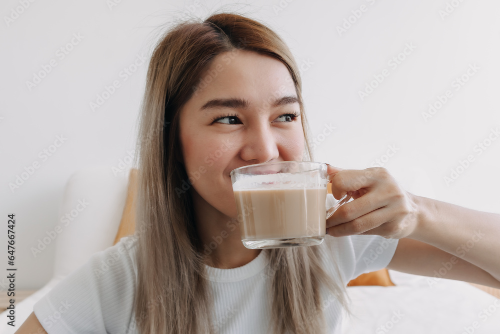 Happy Asian Thai woman drinking coffee milk at apartment look at something. Happy Asian Thai woman drinking coffee milk at apartment look at something.