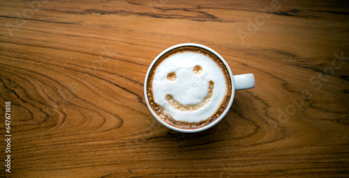 Cup of cappuccino coffee delicious hot coffee with foam milk and smile on color background, top view. Happy morning, good mood, inspiration