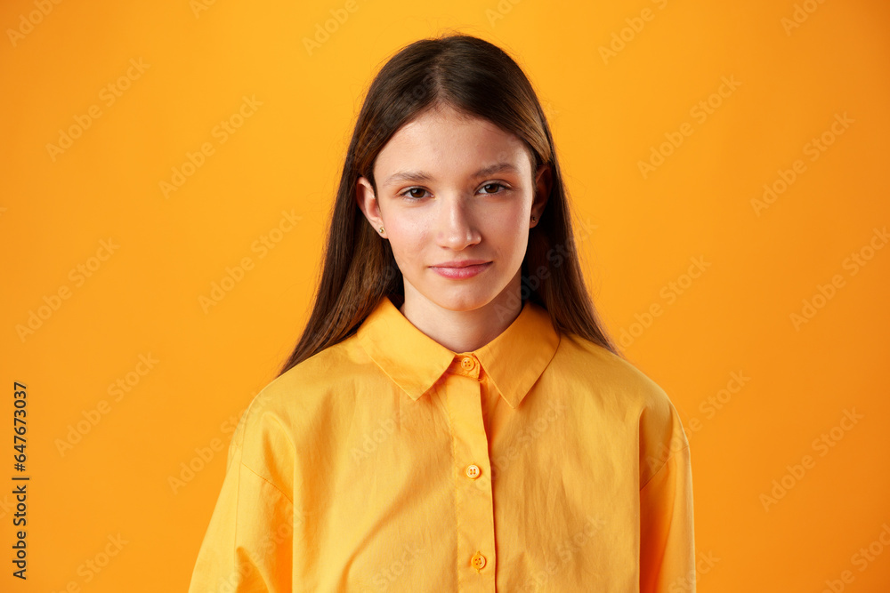Photo of teen girl smiling portrait against yellow background in studio Photo of teen girl smiling portrait against yellow background in studio