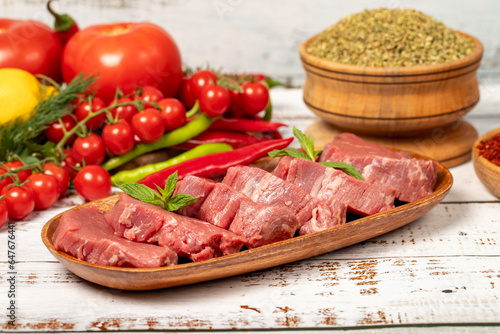 Raw beef tenderloin on wood background. Raw beef tenderloin with herbs and spices. Close up