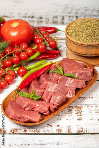 Raw beef tenderloin on wood background. Raw beef tenderloin with herbs and spices