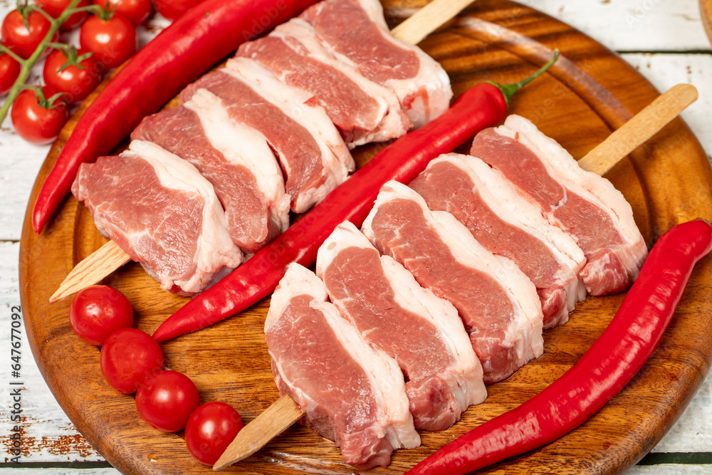 Raw lamb tenderloin on wood background. Raw lamb tenderloin with herbs and spices. Close up Raw lamb tenderloin on wood background. Raw lamb tenderloin with herbs and spices. Close up
