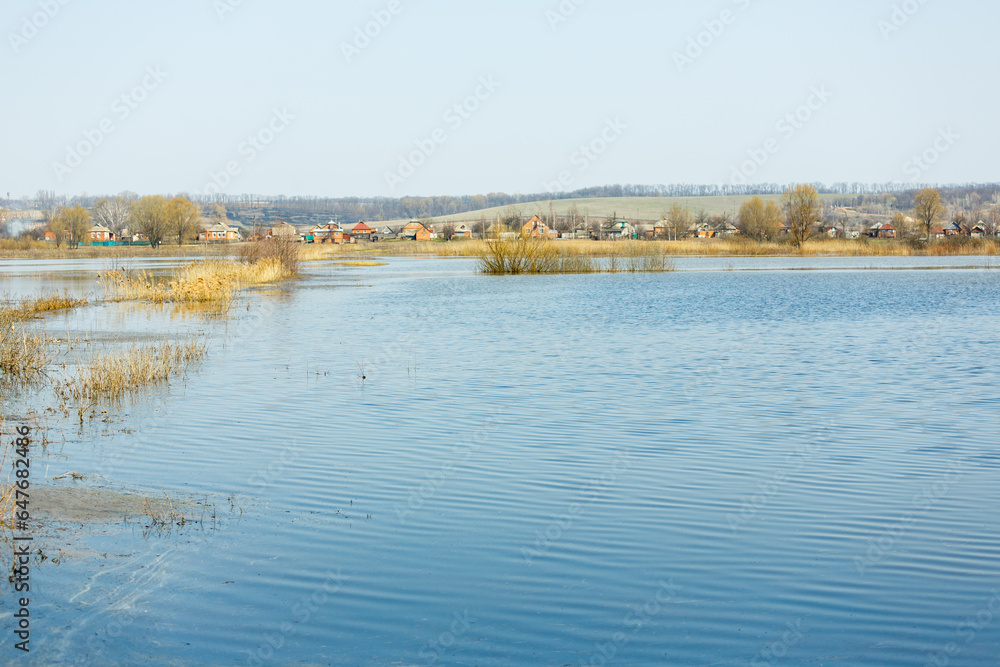 The spring flood flooded the field and the village road. Flood water in fields, countryside. Trees in the water. Climate change, global warming. Global flood risks under climate change. The spring flood flooded the field and the village road. Flood water in fields, countryside. Trees in the water. Climate change, global warming. Global flood risks under climate change.