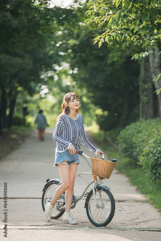 A young woman is riding a bicycle in the park.