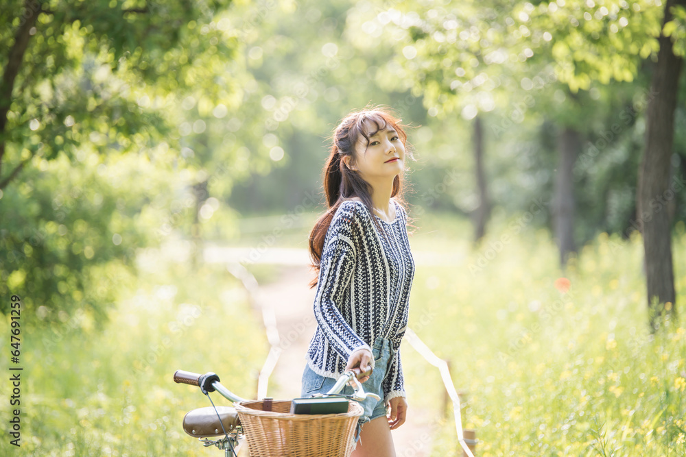A young woman is riding a bicycle in the park. A young woman is riding a bicycle in the park.