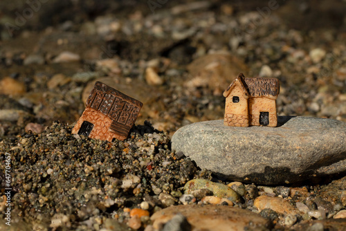 Two miniature houses in sand and on rock (stone). Close-up. Wise and solid foundation gospel parable of Jesus Christ, obedience, and faith in God. Christian biblical concept. photo