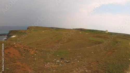 super wide angle horizontal look out view to flat desert field formation on dry deserted hill top with brown bushes grass overlook to ocean horizon  with clear blue sky day  in Dongji Tong-kiat sū photo