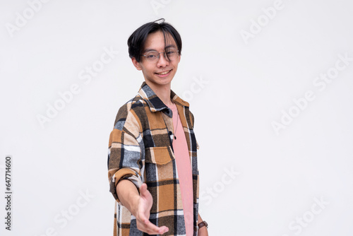 A young asian man offers a helping hand. Agreeing to terms or introducing himself. Isolated on a white background.