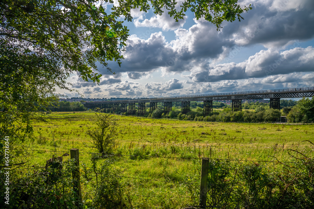 A tree framed view towards the Bennerley Viaduct over the Erewash canal in summertime