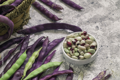 Schilderij op canvas Bowl with fresh organic beans and purple bean pods on a table.