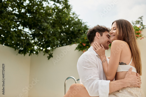 tattooed woman smiling and hugging passionate man during summer vacation, romantic getaway © LIGHTFIELD STUDIOS