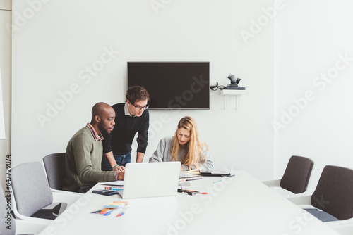 three colleagues working together for project in modern office photo
