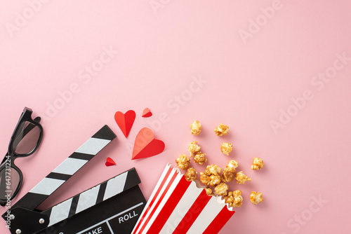 Enjoy a romantic movie date night with caramel popcorn, 3D glasses, paper hearts, and a clapperboard on a pretty pastel pink background