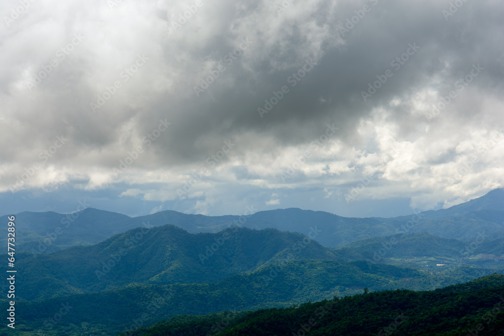 Naklejka premium Strom dark blue cloudy sky over the mountains range in rainy season.