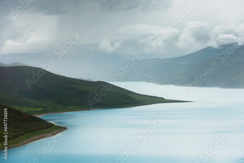 Hilly and mountainous landscape with sacred lake under a cloudy sky; Shannan xizang china photo