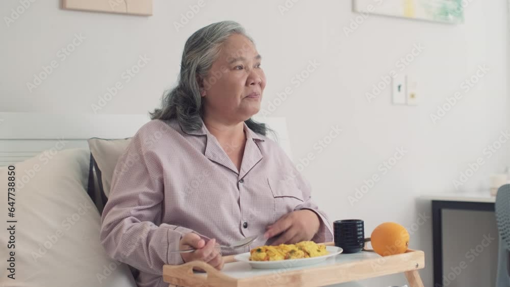 Medium shot of senior sick woman in pajama eating breakfast from tray while sitting on bed at homeMedium shot of senior sick woman in pajama eating breakfast from tray while sitting on bed at home Medium shot of senior sick woman in pajama eating breakfast from tray while sitting on bed at homeMedium shot of senior sick woman in pajama eating breakfast from tray while sitting on bed at home
