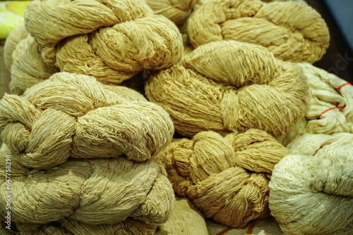 Thread from natural cotton dyed with natural brown color, brown tone color threads.Selection of brown color yarn wool on shopfront. Knitting background.Knitting yarn for handmade local clothes.