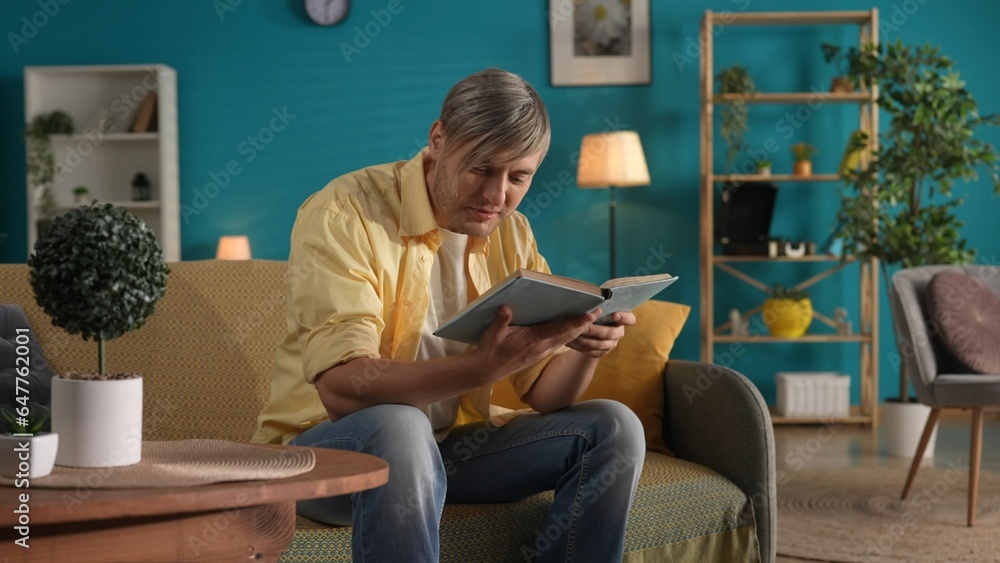 Man reads a book while sitting at home on the couch. The concept of family happiness, leisure, rest at home.