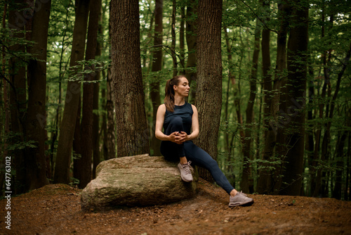 Portrait of young athletic woman in nature having break or rest after workout, exercise or training